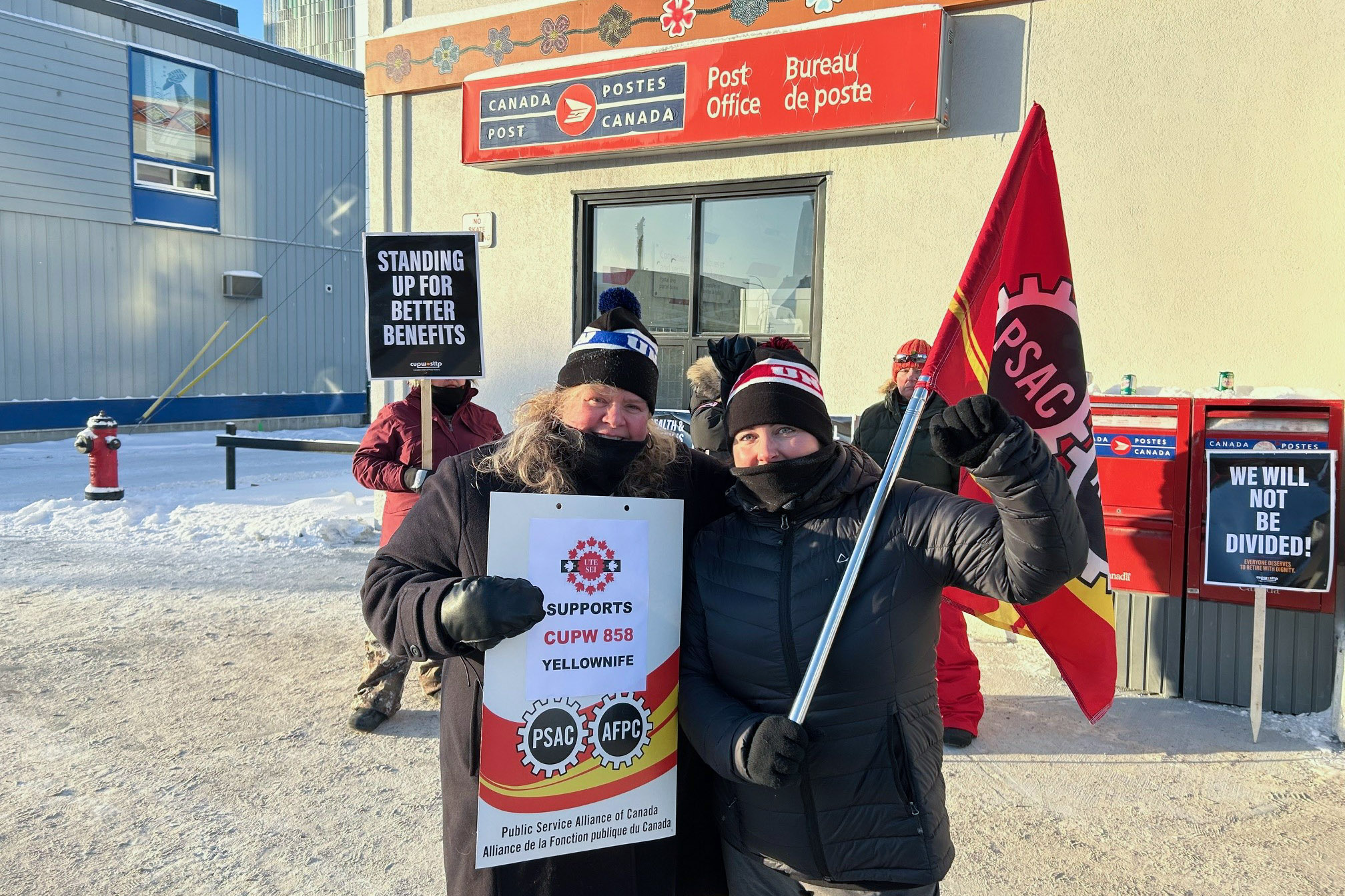 Darlene Bembridge holding a sign UTE supports CUPW 858 Yellowknife