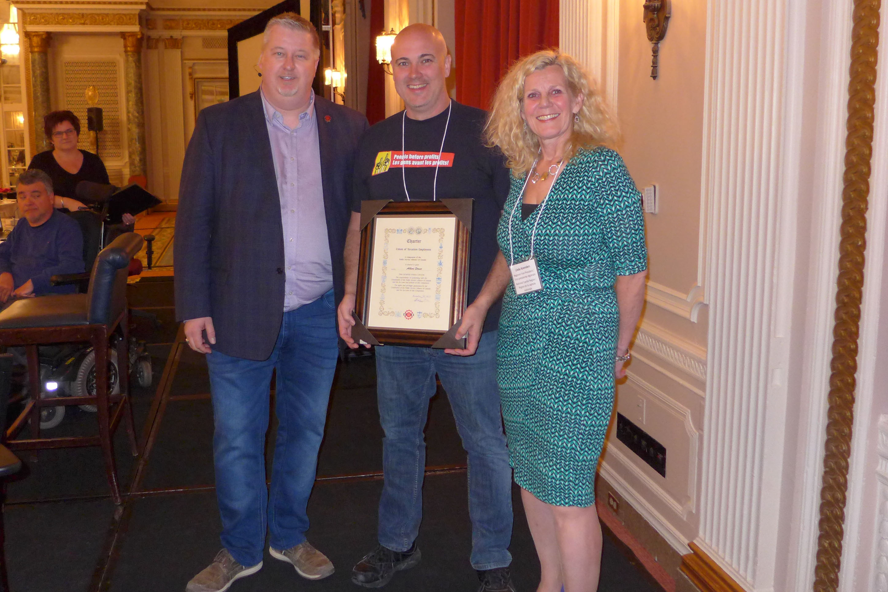 Le président national, Marc Brière et Linda Koenders, VPR pour la RCN, présentent Scott Henneberry, président de la section locale 70022 - rue Albert, avec la charte de la section locale