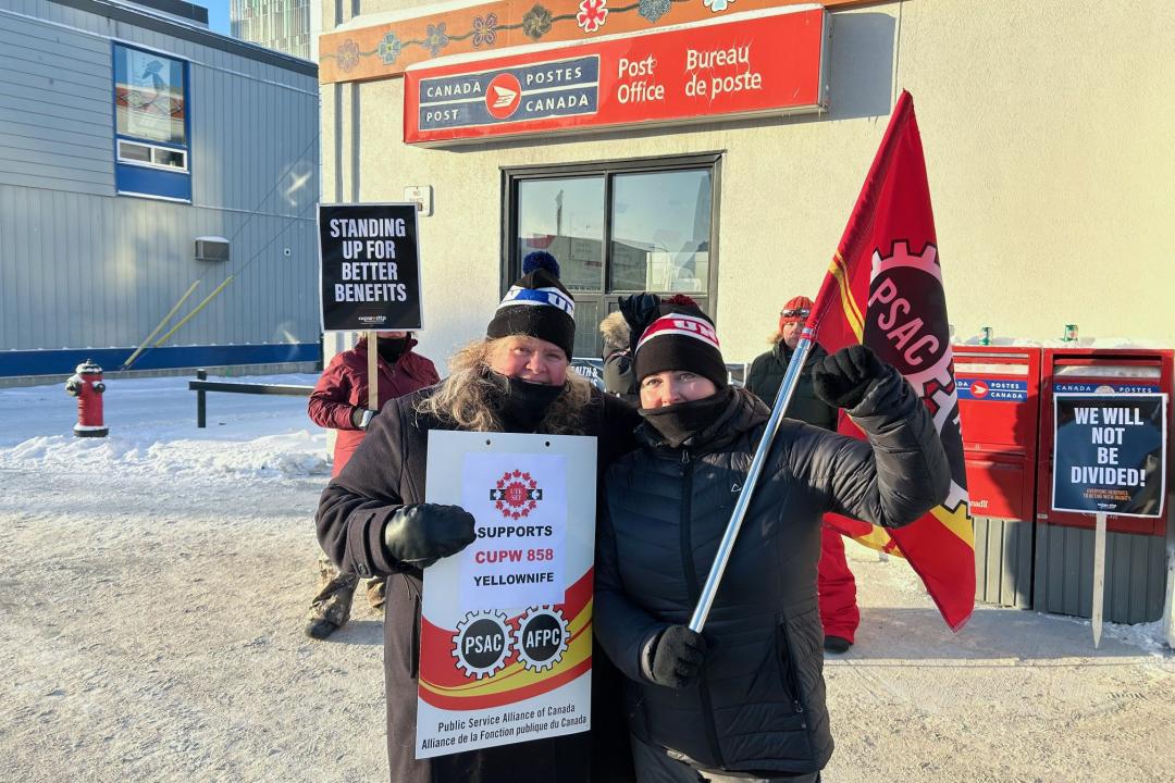 Darlene Bembridge tient une pancarte Le SEI appuie le STTP 858 Yellowknife