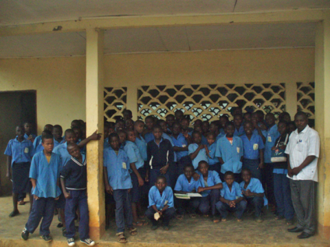a group of children in front of their school